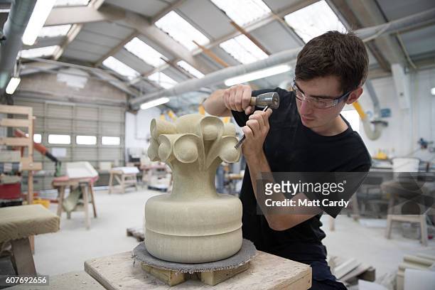 Stonemason Christian Sullivan, who has recently completed a four-year stonemasonry apprenticeship, completes a new finial, which will go on the roof...
