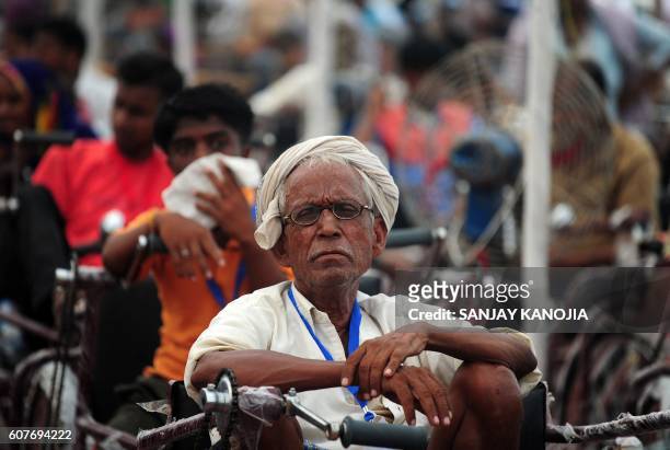 An Indian physically challenged man sits on a tricycle distributed at a function organized by the Indian government in Allahabad on September 19,...