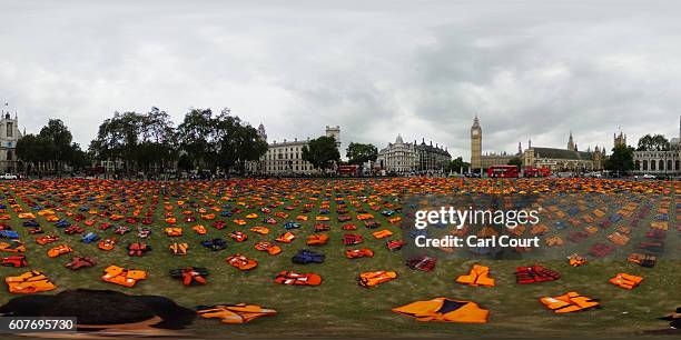 Lifejackets that have been used by refugees to cross the sea to Europe are laid out in Parliament Square on September 19, 2016 in London, England....