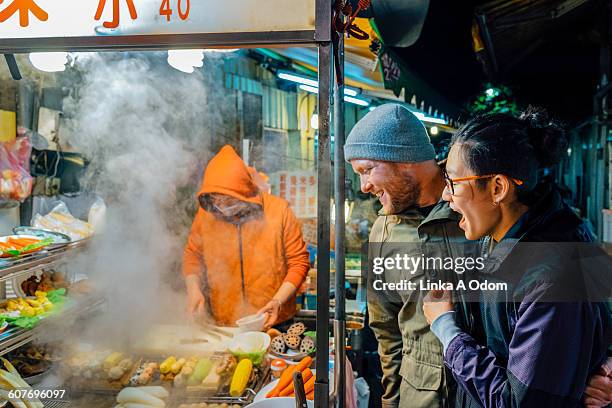 mixed race couple shopping in asian market - taiwan night market stock pictures, royalty-free photos & images