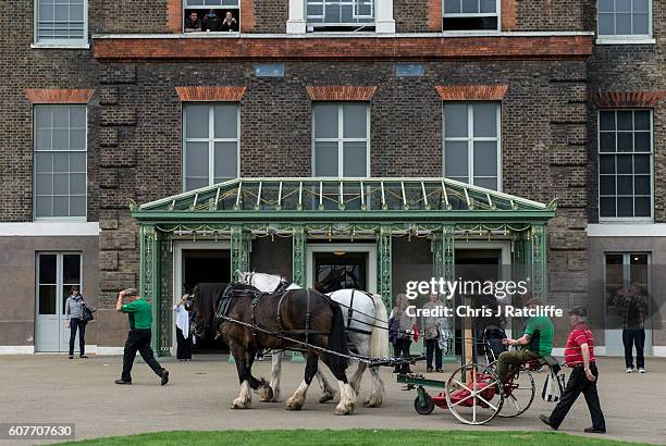 Shire horses Heath and Tom pull an antique horse drawn mower driven by Edward MacDowell past the front entrance of Kensington Palace as they take...