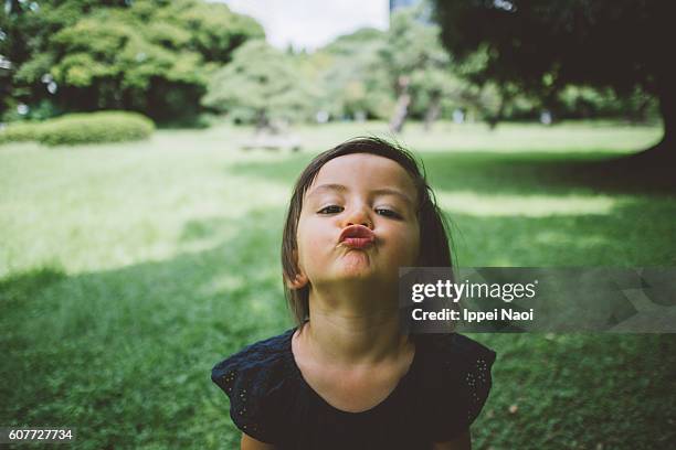 adorable toddler girl making kissing lips toward camera - hacer pucheros fotografías e imágenes de stock