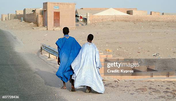 africa, north africa, mauritania view of two young men holding hands walking together towards village (year 2007) - mauritania stock pictures, royalty-free photos & images