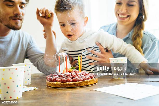 zu hause mit familie feiern geburtstag für kleine jungen - blowing out candles pov stock-fotos und bilder