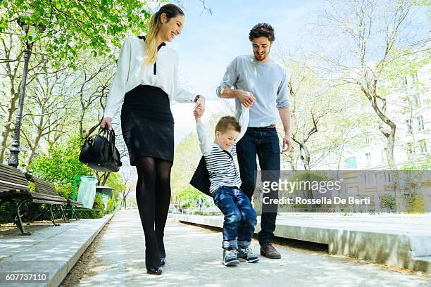 happy family walking through the park taking son to school - couple school stockfoto's en -beelden