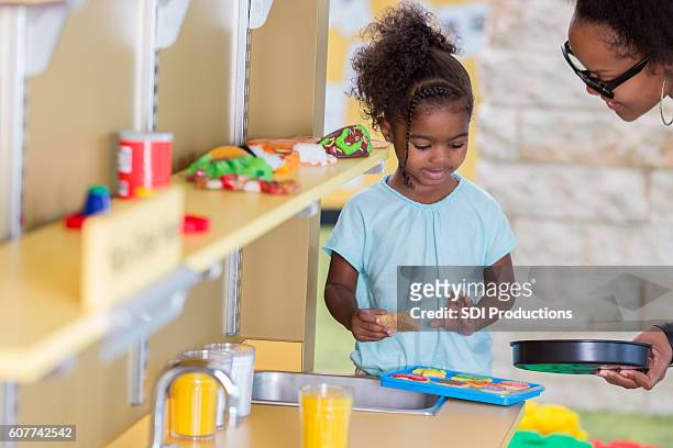 cute toddler girl playing with pretend kitchen with her mom - sweet little models stock pictures, royalty-free photos & images