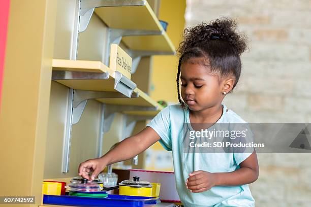 young preschool girl playing with a toy kitchen - sweet little models stock pictures, royalty-free photos & images
