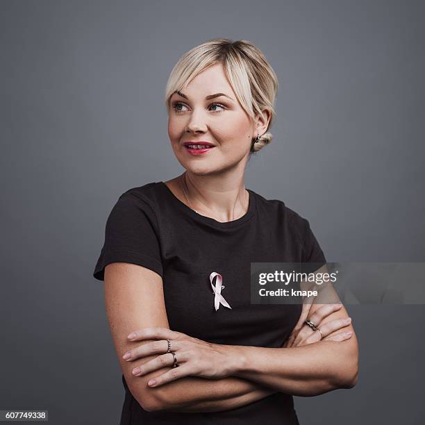 woman with pink ribbon breast cancer awareness symbol - plain t shirt stock pictures, royalty-free photos & images