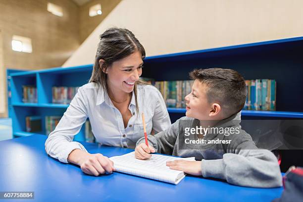 teacher with a student at the library - coach stock pictures, royalty-free photos & images