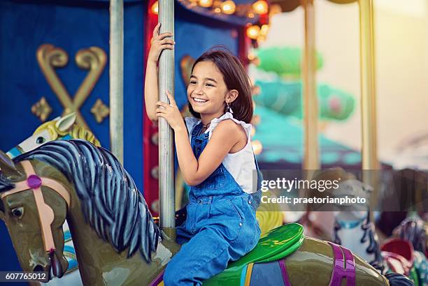 little girl on carousel - amusement park ride stockfoto's en -beelden
