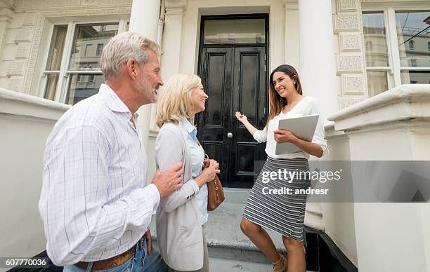 real estate agent showing house to a couple - house showing stock pictures, royalty-free photos & images