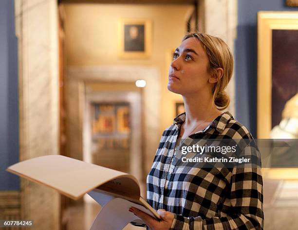 female art student at gallery, looking at painting - museum stockfoto's en -beelden
