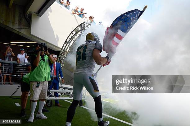 Rear view of Jacksonville Jaguars Paul Posluszny holding USA flag and about to take field before game vs Green Bay Packers at Everbank Field....