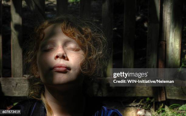 close-up of a teenage girl leaning against plank wall - kid day dreaming stock pictures, royalty-free photos & images