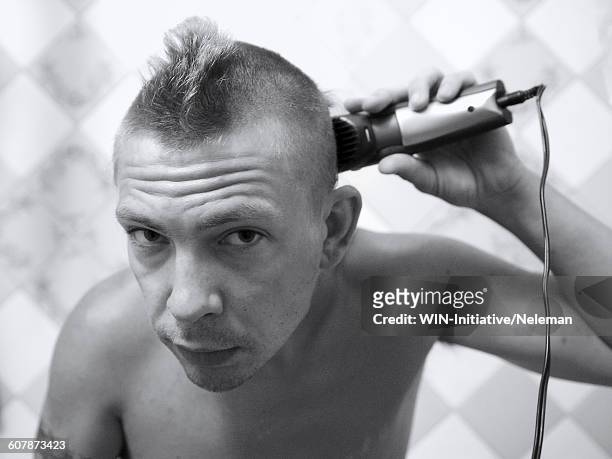 portrait of a man shaving with an electric razor - shaving head stock pictures, royalty-free photos & images