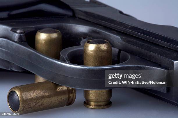 close-up of a handgun with bullets - arms of steel stock pictures, royalty-free photos & images