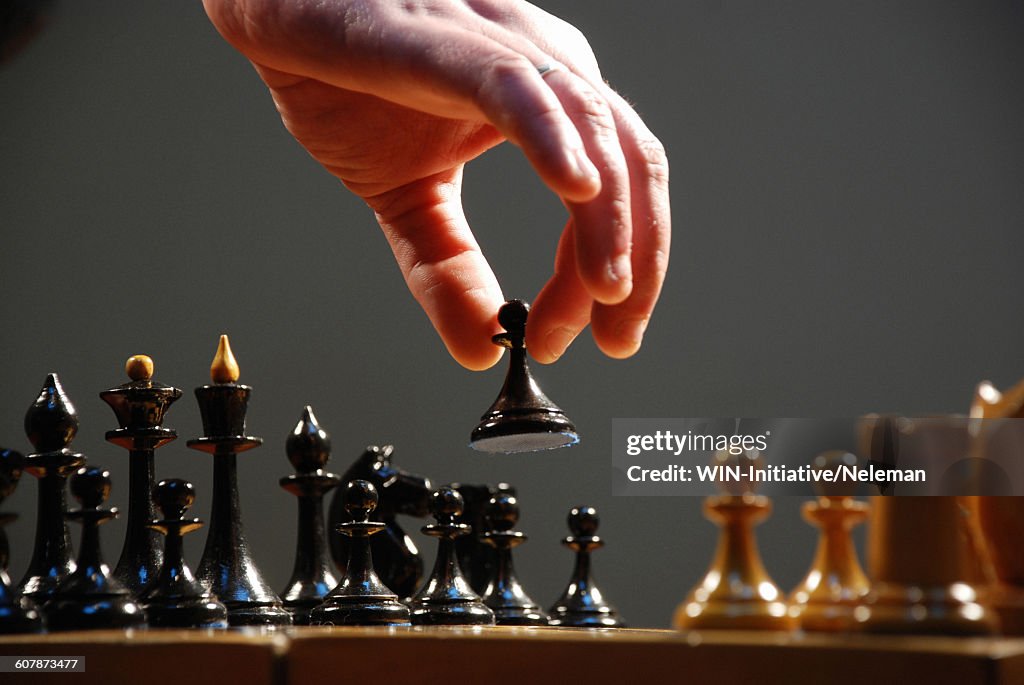 Hand moving the pieces of a chess board, close-up