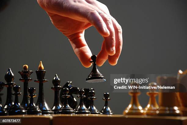 hand moving the pieces of a chess board, close-up - scacchi foto e immagini stock