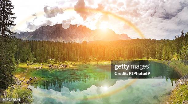 rainbow on carezza lake  - trentino alto adige - italy - catinaccio rosengarten stock pictures, royalty-free photos & images