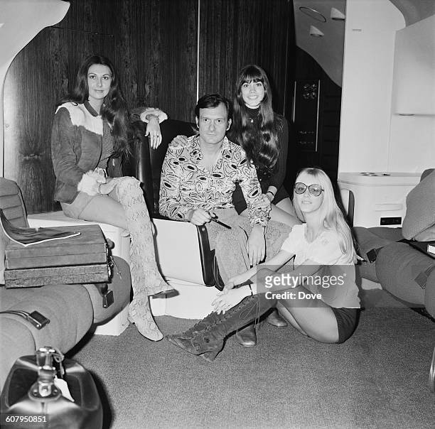 American publisher Hugh Hefner in his aircraft at London Airport, before flying back to Chicago, 20th February 1971. With him are Playboy models...