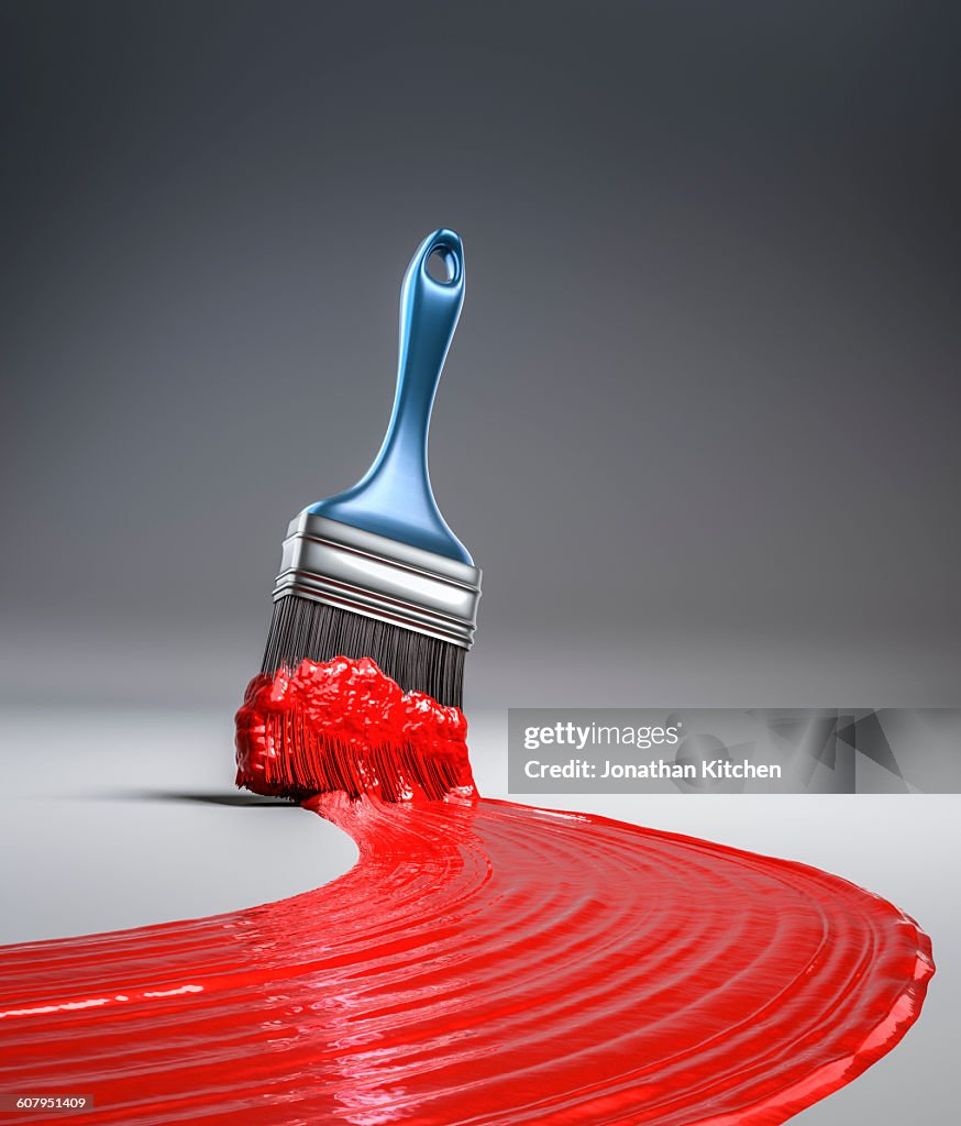 Paint brush in red paint