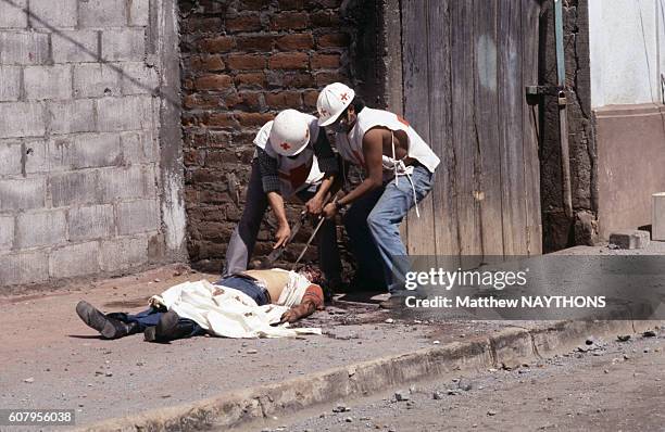 Image contains graphic content) Infirmiers de la croix rouge évacuant un cadavre lors de la guerre civile en juillet 1979 au Nicaragua.