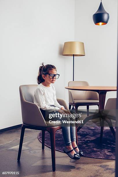 girl sitting on chair with oversized glasses - kid sitting stock pictures, royalty-free photos & images