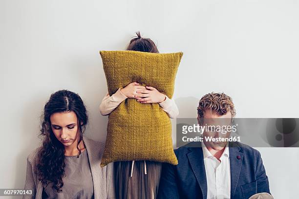 couple having relationship conflict with their daughter hiding her face behind cushion - divorce kids fotografías e imágenes de stock