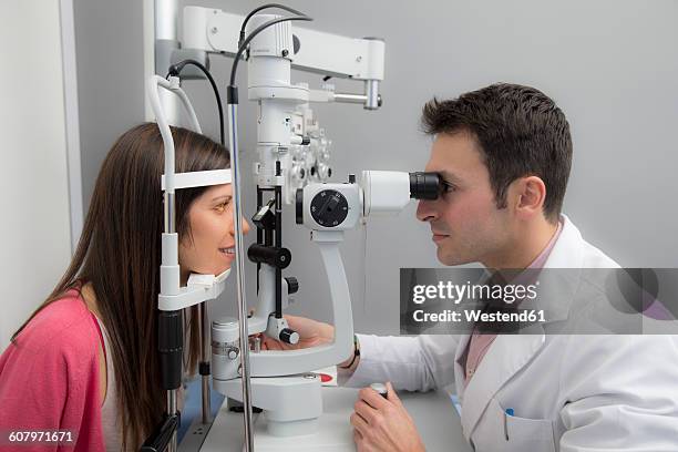 woman at the optometrist making an eye test - optical equipment stock pictures, royalty-free photos & images