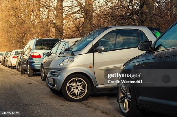 small car parking sideways to the other cars - kleinwagen stock-fotos und bilder