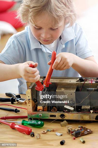 little boy disassembling an old radio - dismantling bildbanksfoton och bilder