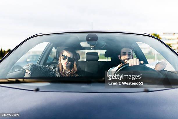 young couple driving in a car - facing photos et images de collection