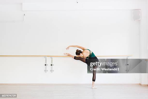 dancer practicing at the barre in the gym - barre fitness foto e immagini stock