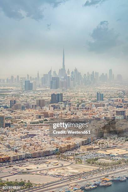 dubai, aerial view of deira and bur dubai with the creek and the skyline of downtown, with burj khalifa in the distance - deira stockfoto's en -beelden