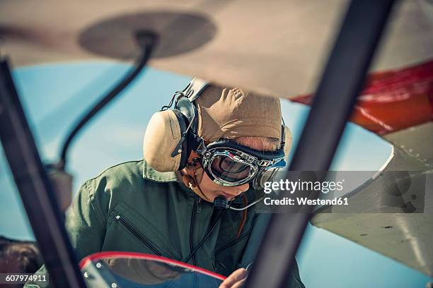 germany, dierdorf, boy sitting in biplane wearing old pilot outfit - avião biplano - fotografias e filmes do acervo