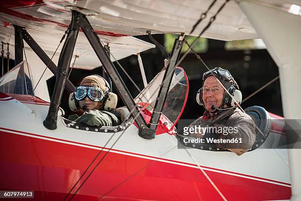germany, dierdorf, grandfather and grandson sitting on old biplane - biplane stock pictures, royalty-free photos & images