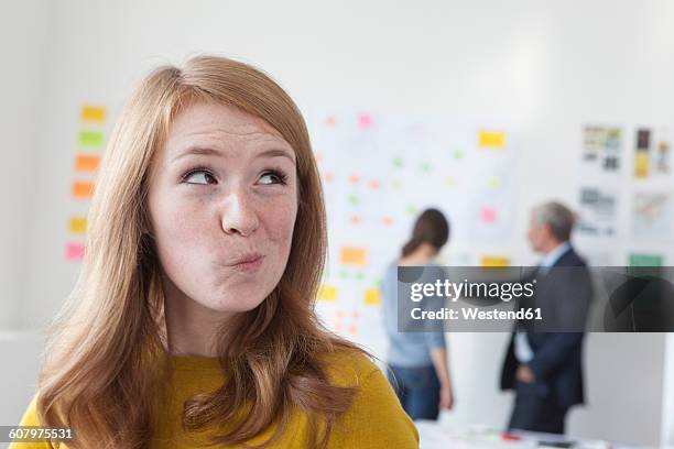 young woman in office thinking - suspicion fotografías e imágenes de stock