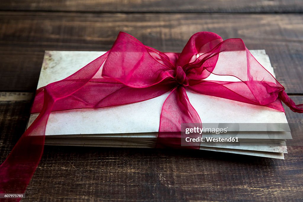 Stack of old love letters tied with red ribbon