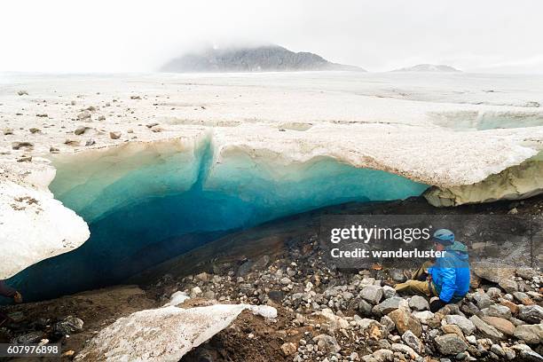 senior man admires ice cave in alaska - voor anker gaan stockfoto's en -beelden