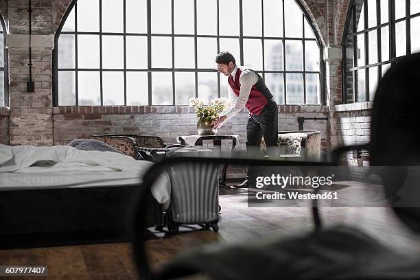 butler in hotel room, flower vase - huishoudelijke dienstverlening stockfoto's en -beelden