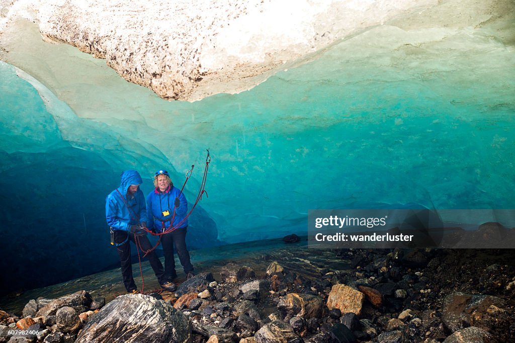 Nervous woman prepares to rappel in ice cave