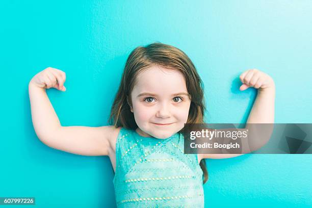 strong american girl looking at camera shows muscles raising arms - 4 5 år bildbanksfoton och bilder