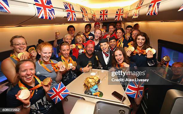 Members of the Paralympics GB Team show their medals as the British Airways cabin crew pour champagne prior to the flight back from Galeao Airport on...