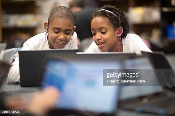 fourth grade students work on laptops in class. - school boy girl stock-fotos und bilder