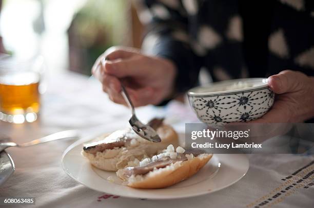 senior woman sprinkling onions over raw herring - herring stock pictures, royalty-free photos & images