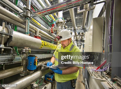 Worker inspecting a solid waste processing plant Worker inspecting a solid waste processing plant