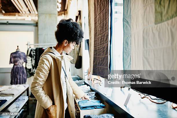 woman shopping for clothing in boutique shop - shopping candid stock pictures, royalty-free photos & images