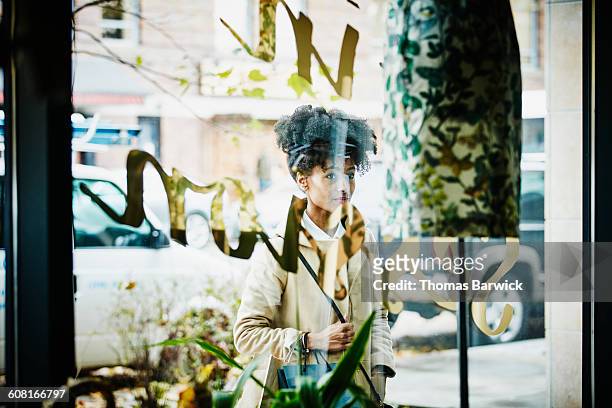 smiling woman window shopping at boutique shop - window shopping stock pictures, royalty-free photos & images