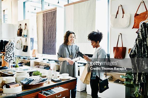 customer completing transaction on digital tablet - retail place stock pictures, royalty-free photos & images