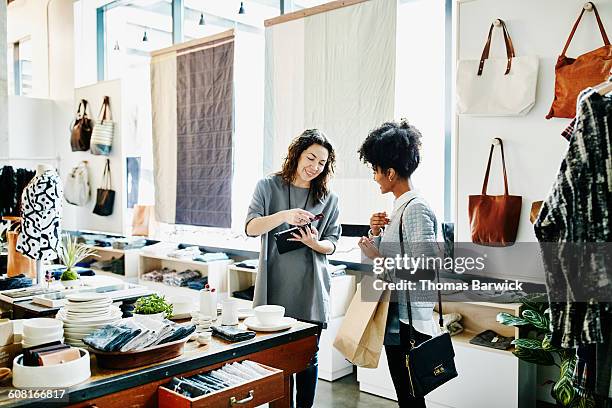 owner processing credit card with digital tablet - white purse stock-fotos und bilder